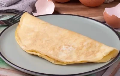 Fotografía de una crepioca con avena doblada sobre un plato gris medio con borde negro.